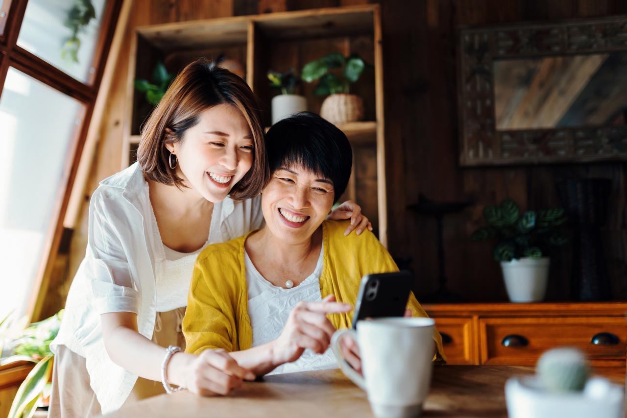 Mother_and_daughter_using_smartphone_together_at_home.jpg