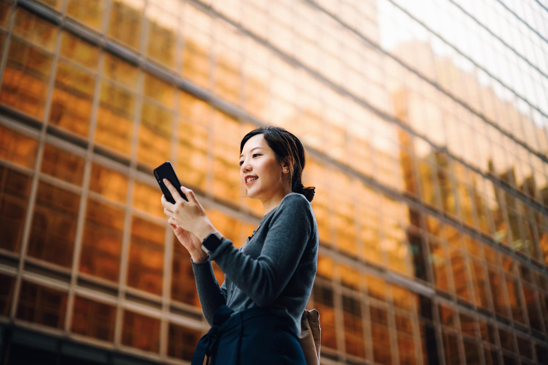 Businesswoman_managing_online_banking_with_mobile_app.jpg