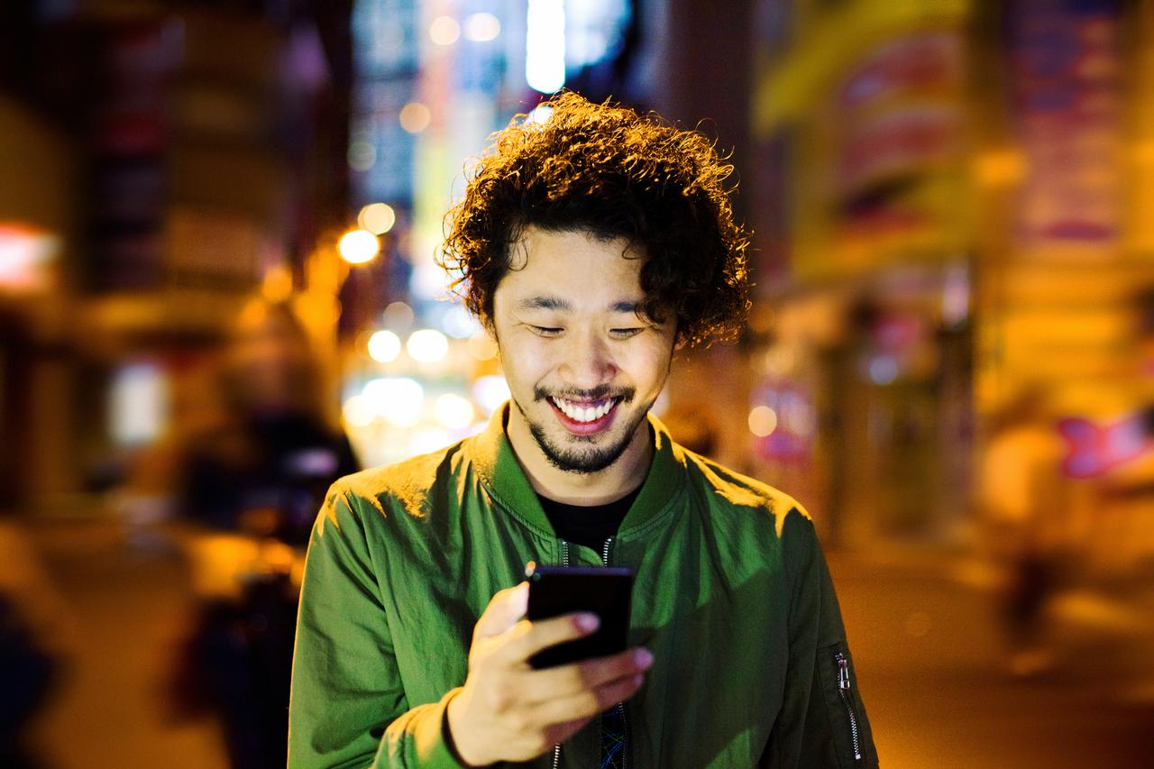 Young_man_with_smart_phone_at_night.jpg